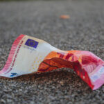 Un billet de 10 euros froissé au sol