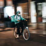 Un livreur Deliveroo au travail à vélo sur fond flou