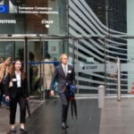Des employés en costume sortent du bâtiment Berlaymont de la Commission européenne à Bruxelles