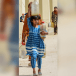 Une jeune fille portant de l'eau pendant une vague de chaleur au Pakistan.